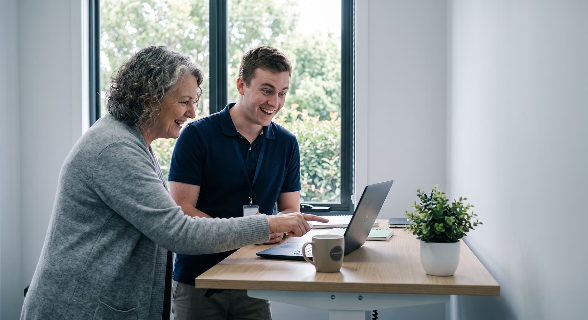 Two people reviewing support information together on a laptop